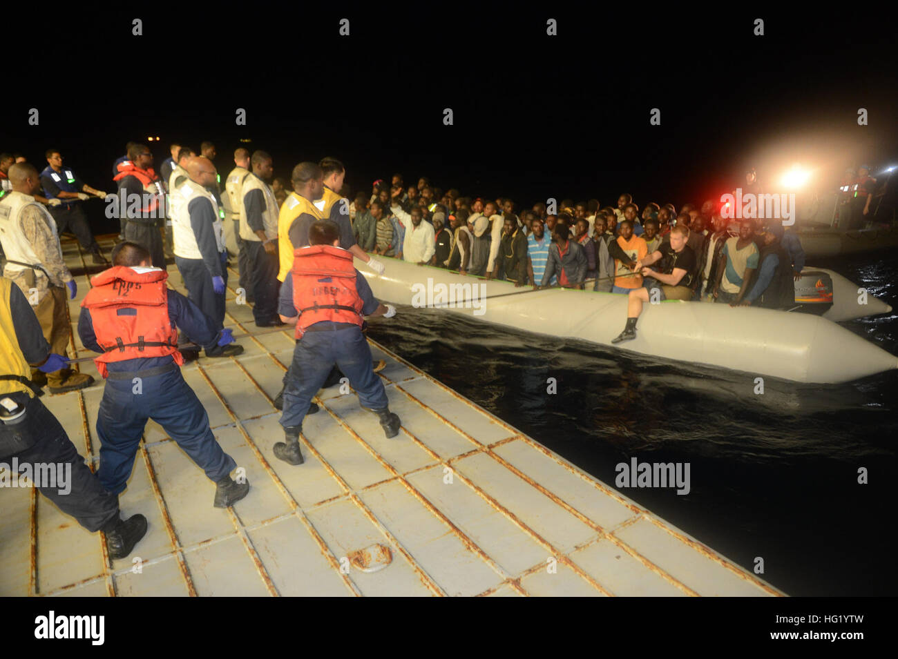 U.S. Sailors aboard the amphibious assault ship USS Bataan (LHD 5) transfer several persons in distress to the Armed Forces of Malta offshore patrol vessel P61 in the Mediterranean Sea June 6, 2014. The Bataan and the guided missile frigate USS Elrod (FFG 55) provided assistance including food, water, medical attention and temporary shelter to 282 people after receiving a report that an Italian military marine patrol aircraft sighted six small vessels, one of which was sinking. The Bataan, with the embarked 22nd Marine Expeditionary Unit, was operating in the U.S. 6th Fleet area of operations  Stock Photo