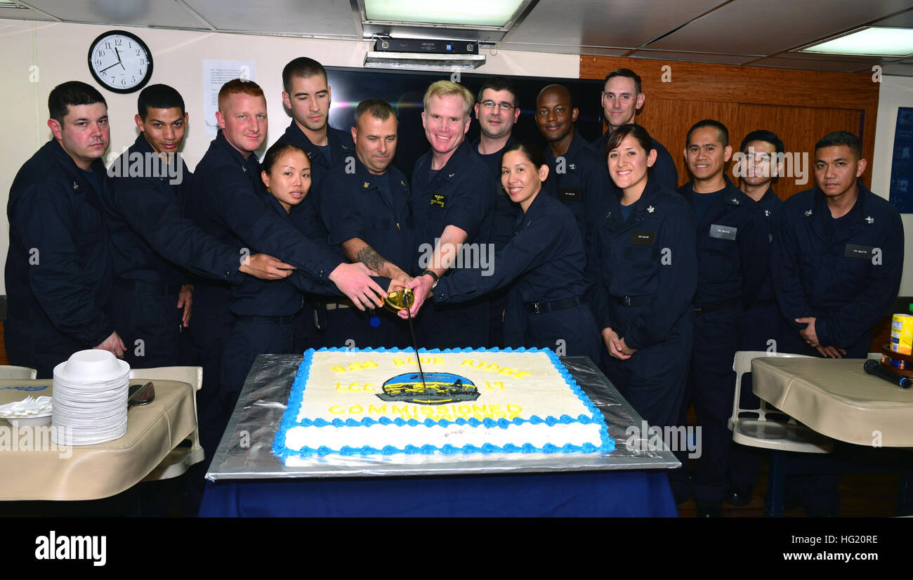 U.S. 7th Fleet flagship USS Blue Ridge (LCC 19) Commanding Officer Capt. Richard McCormack, center right, and Command Master Chief Mark Tomlinson, center left, cut a cake in commemoration of Blue Ridge becoming the oldest active duty ship the U.S. Navy, next to the USS Constitution.  Blue Ridge port visits strengthen military-to-military relationships based on common interests related to maritime security, counterterrorism, defense, trade and security of the Indo-Asia-Pacific region.  (U.S. Navy Photo by Mass Communication Specialist 3rd Class Kelby Sanders) USS Blue Ridge operations 140815-N- Stock Photo