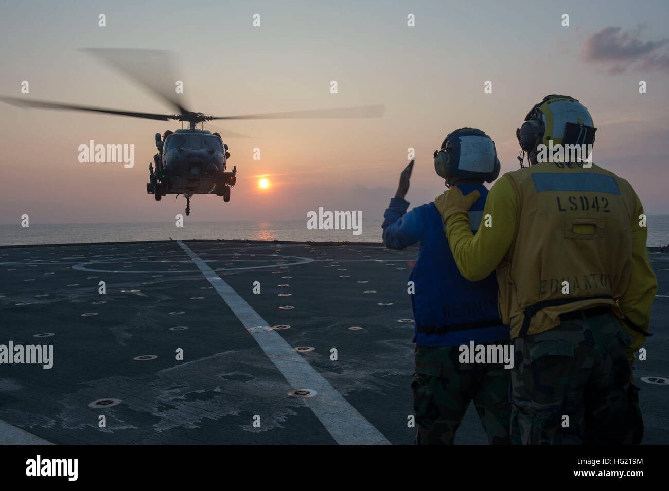 Boatswain’s Mate 3rd Class Robert Mclymont, from Miramar, Fla., right, and Culinary Specialist Seaman Nicole Little, from Harrisburg, Pa., signal an Air Force HH-60 Pave Hawk, assigned to the 33rd Rescue Squadron, as it lands on the flight deck of the amphibious dock landing ship USS Germantown (LSD 42). Germantown is part of the Peleliu Amphibious Ready Group (#PELARG 14) and is conducting joint forces exercises in the U.S. 7th Fleet area of responsibility. (U.S. Navy photo by Mass Communication Specialist 2nd Class Amanda R. Gray/Released) USS Germantown 140909-N-UD469-334 Stock Photo