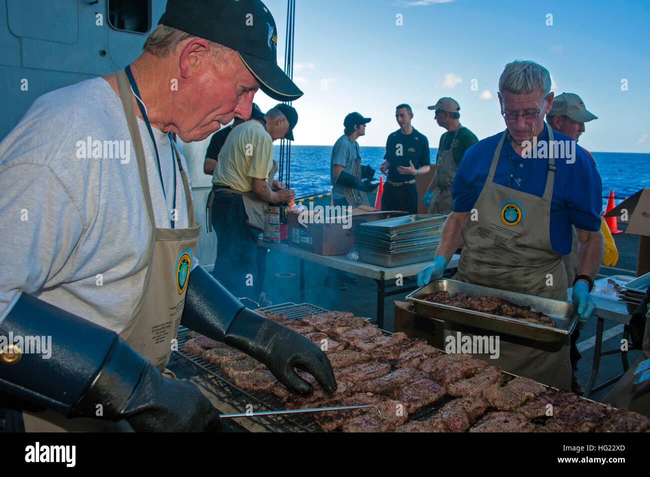 Cooks from the Valley volunteers cook steaks for Sailors stationed aboard the Nimitz-class aircraft carrier USS George Washington (CVN 73). The Cooks from the Valley is a diverse group of businessmen and women who, since 2001, have delivered approximately 53 tons of Harris Ranch, 12oz New York steaks to more than 140,000 Sailors and Marines around the world. (U.S. Navy photo by Mass Communication Specialist Seaman Loni Mae Lopez/Released) USS George Washington operations 141106-N-ZK360-188 Stock Photo