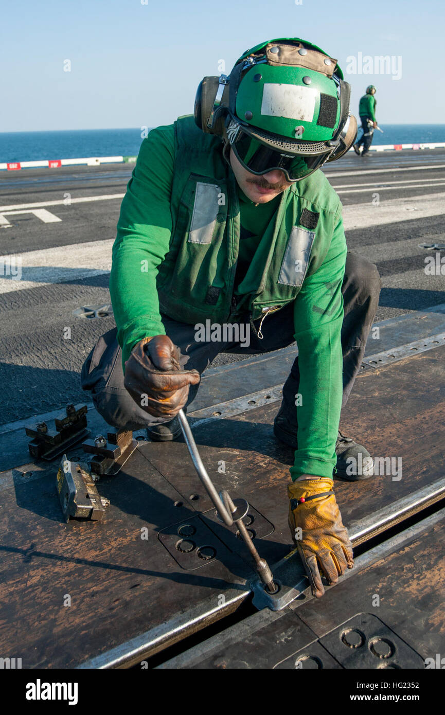 Aviation Boatswain’s Mate (Equipment) 3rd Class Ralph Ellison removes catapult buttons on the
