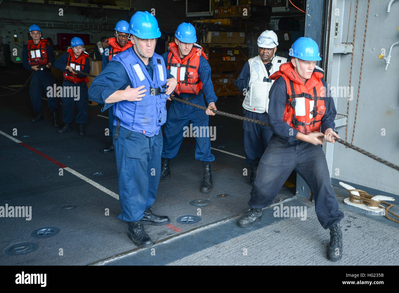 Sailors from the amphibious assault ship USS Peleliu (LHA 5) heave a ...