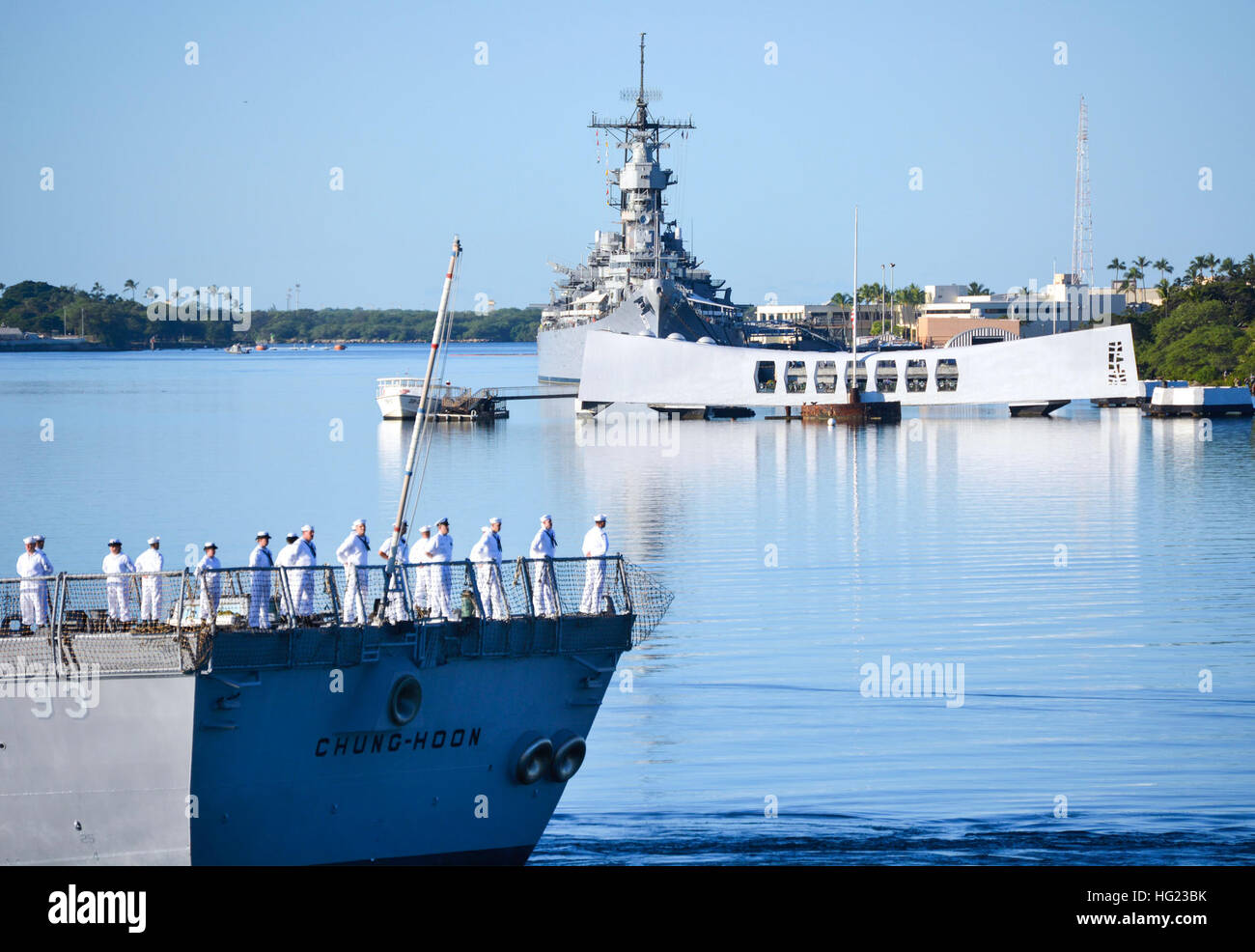 The guided-missile destroyer USS Chung-Hoon (DDG 93) conducts a pass-in-review by the USS Arizona Memorial during the 73rd Anniversary Pearl Harbor Day commemoration ceremony at the Pearl Harbor Visitor Center. More than 2,000 guests, including Pearl Harbor survivors and other veterans, attended the National Park Service and U.S. Navy-hosted joint memorial ceremony at the World War II Valor in the Pacific National Monument. This year's theme focused on 'Preserving the Memory.' (U.S. Navy photo by Mass Communication Specialist 1st Class Katherine Hofman/Released) USS Chung-Hoon operations 14120 Stock Photo
