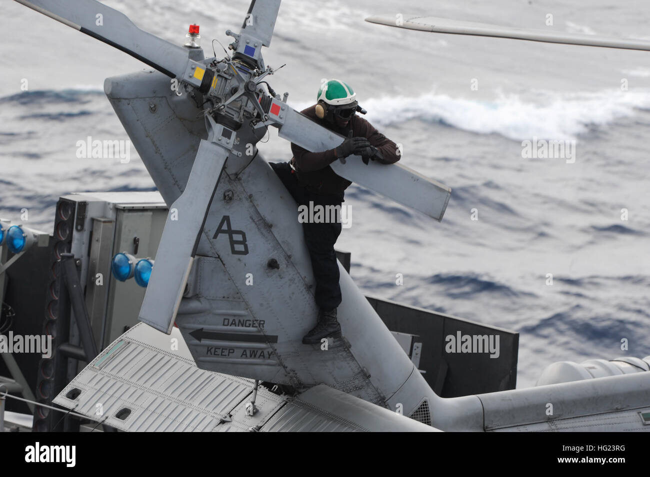 Aviation Structural Mechanic 1st Class Willie Duncan Jr., from Nashville, Tenn., signals a fellow plane captain while performing a post-operational check on the tail rotor of an SH-60F Sea Hawk helicopter attached to the Dragonslayers of Helicopter Anti-Submarine Squadron (HS) 11 on the flight deck of the aircraft carrier USS Theodore Roosevelt (CVN 71). Theodore Roosevelt is  underway participating in a composite training  unit exercise (COMPTUEX), which tests the Theodore Roosevelt Carrier Strike Group's ability to effectively react to real-world scenarios and perform as an integrated unit.  Stock Photo