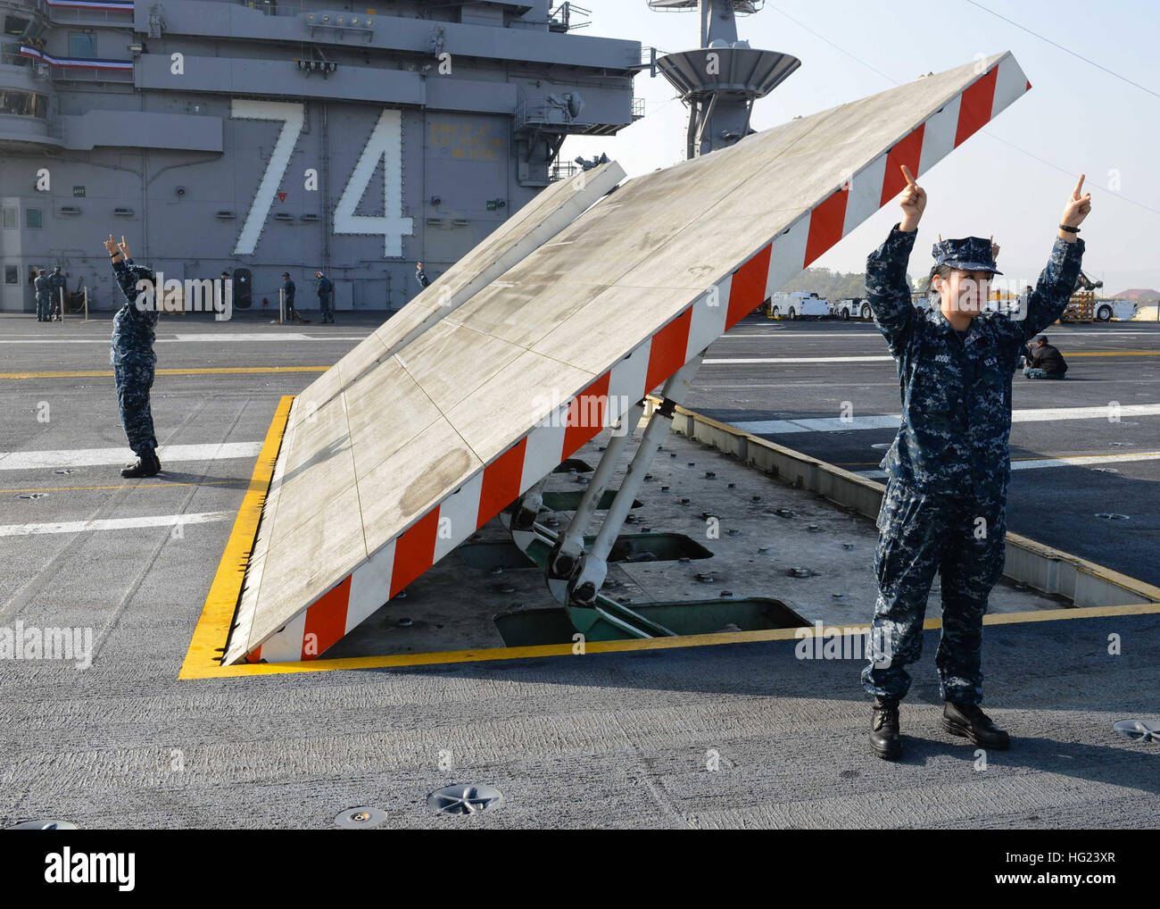 Aviation Boatswain's Mate (Equipment) Airman Jane Wood, from Armarillo, Texas, signals to raise