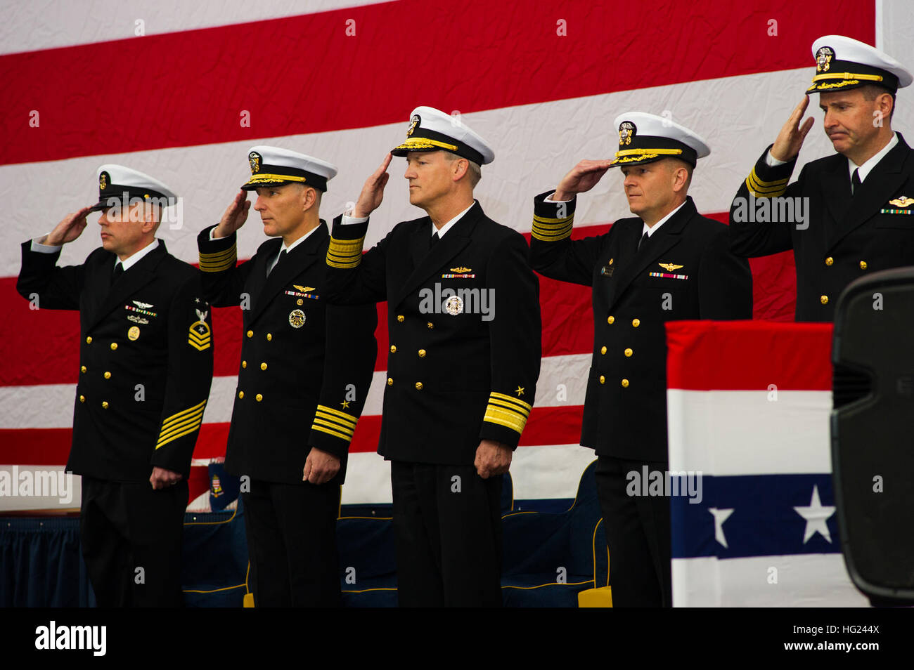 (From left to right) The Nimitz-class aircraft carrier USS George Washington's (CVN 73) Command Master Chief Jason Haka, Capt. Timothy Kuehhas, George Washington's prospective commanding officer, Vice Adm. Robert Thomas, commander, U.S. 7th Fleet, Capt. Greg Fenton, George Washington's commanding officer, and Cmdr. Joseph Coffey, George Washington's command chaplain, salute as color guard presents colors during a change of command ceremony in the ship's hangar bay. Kuehhas relieved Fenton as George Washington's commanding officer. George Washington and its embarked air wing, Carrier Air Wing ( Stock Photo