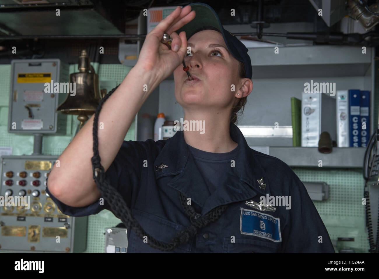150206-N-IK388-014  PACIFIC OCEAN (Feb. 06, 2015) – Boatswain’s Mate 2nd Class Tara Delezenski, from Wilton, California, pipes an announcement to the crew from the bridge of amphibious transport dock ship USS San Diego (LPD 22). San Diego, part of the Makin Island Amphibious Ready Group, and the embarked 11th Marine Expeditionary Unit are returning to homeport San Diego following a seven-month deployment to the Western Pacific and the U.S. Central Command areas of operation. (U.S. Navy photo by Mass Communication Specialist 2nd Class Stacy M. Atkins Ricks/ Released) USS San Diego bridge operat Stock Photo