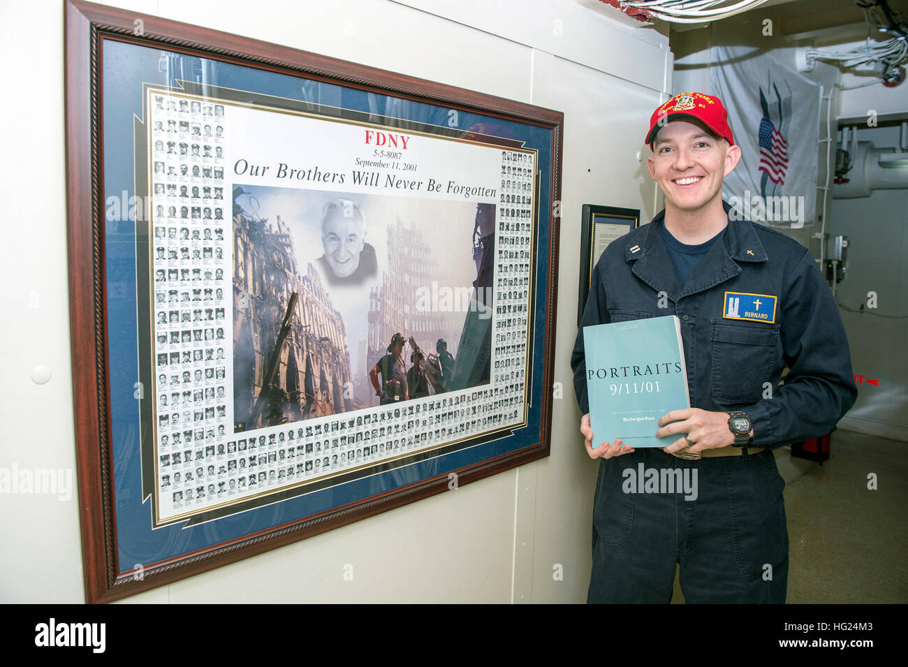 150220-N-XG464-038  ARABIAN GULF (Feb. 20, 2015) - Lt. Justin Bernard, an Aurora, Colo., native and chaplain stationed aboard the amphibious transport dock ship USS New York (LPD 21), poses with a poster of the 343 firefighters who perished during the 9/11 terrorist attacks. New York is a part of the Iwo Jima Amphibious Ready Group (ARG) and, with the embarked 24th Marine Expeditionary Unit (MEU), is deployed in support of maritime security operations and theater security cooperation efforts in the U.S. 5th Fleet area of operations. (U.S. Navy photo by Mass Communication Specialist 3rd Class J Stock Photo