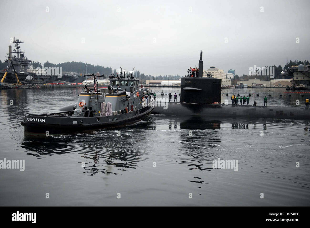 150225-N-JY507-049 BREMERTON, Wash. (Feb. 25, 2015) – The Los Angeles-class fast-attack submarine USS Bremerton (SSN 698) is escorted by the YTZ-779 Manhattan to Pier Delta at Naval Base Kitsap-Bremerton prior to mooring. USS Bremerton is making a namesake visit to Bremerton, Wash., for the first time since 2012. (U.S. Navy photo by Mass Communication Specialist 3rd Class Seth Coulter/Released) USS Bremerton returns for namesake visit 150225-N-JY507-049 Stock Photo