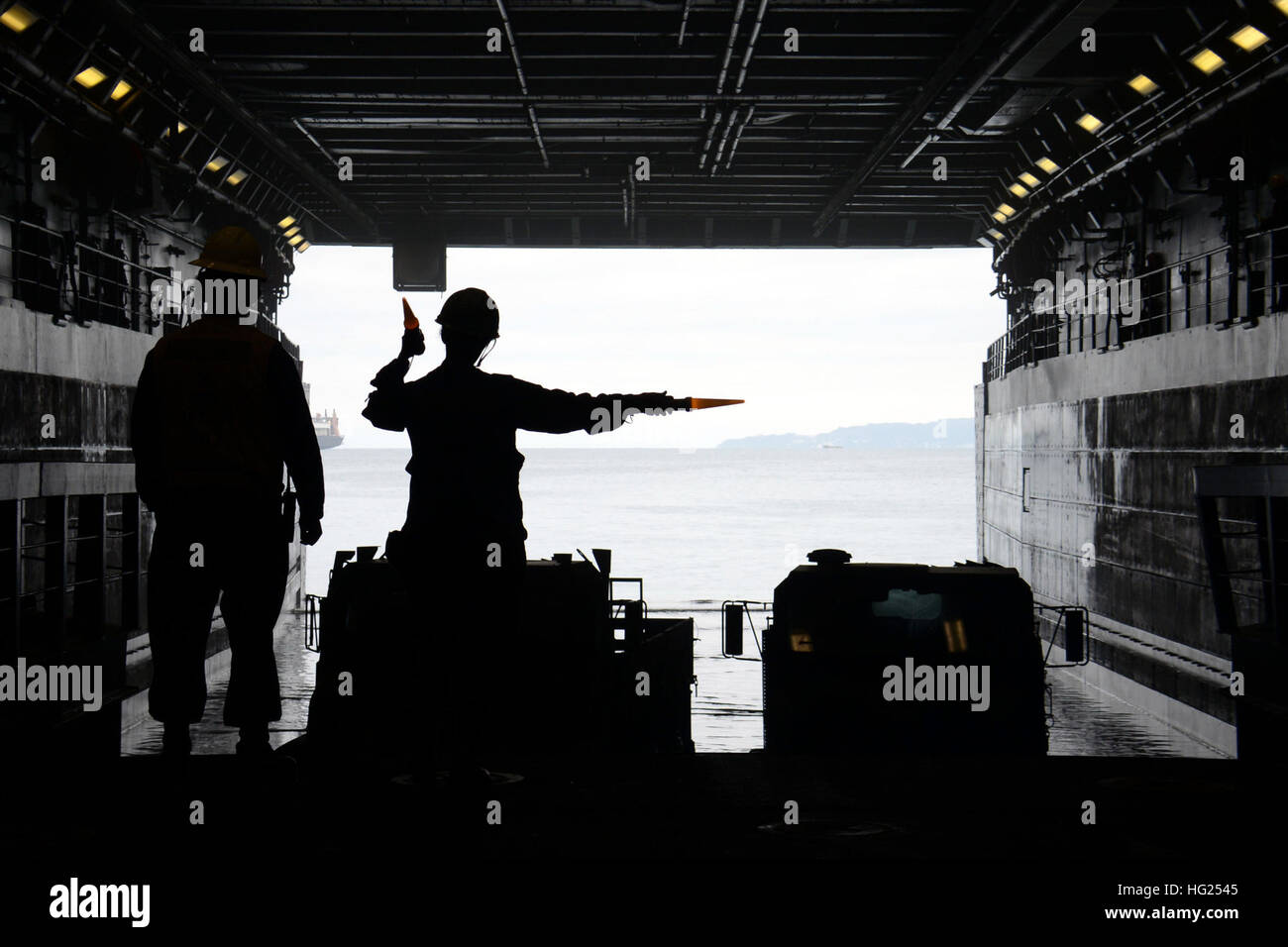 150305-N-BB534-398 OKINAWA, Japan  (Mar. 05, 2015) Seaman Saada Farah directs vehicles in the well deck aboard the forward deployed amphibious transport dock ship USS Green Bay (LPD 20).  Green Bay is replacing the decommissioned Austin-class amphibious transport dock ship USS Denver (LPD 9), previously forward-deployed to Sasebo, and will enhance amphibious presence in the U.S. 7th Fleet as part of the U.S. Navy's long-range plan to send the most advanced and capable units to the Asia-Pacific region. (U.S. Navy photo by Mass Communication Specialist 1st Class Elizabeth Merriam /Released). USS Stock Photo