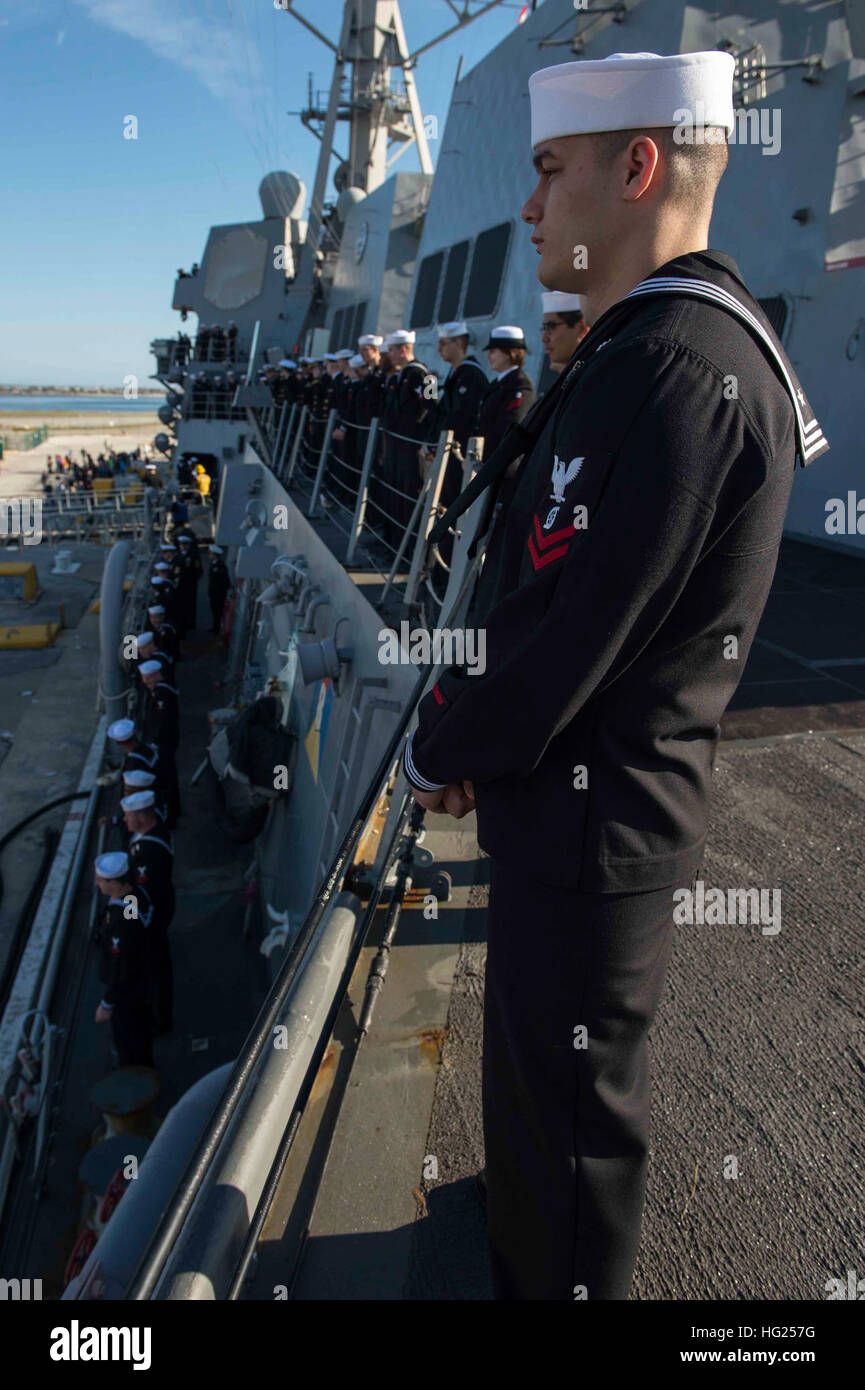 150309-N-VC236-008  MAYPORT, Fla. (March 9, 2015) - Sailors assigned to the Arleigh Burke-class guided-missile destroyer USS Farragut (DDG 99) man the rails as the ship prepares to depart Naval Station Mayport. Faragut is part of the Theodore Roosevelt Carrier Strike Group (TRCSG), which is composed of the Nimitz-class aircraft carrier USS Theodore Roosevelt (CVN 71), Carrier Air Wing (CVW) 1, the guided-missile cruiser USS Normandy (CG 60), and the guided-missile destroyers USS Winston S. Chrurchill (DDG 81)  and USS Forrest Sherman (DDG 98). TRCSG will conduct operations in the U.S. Navy’s 5 Stock Photo