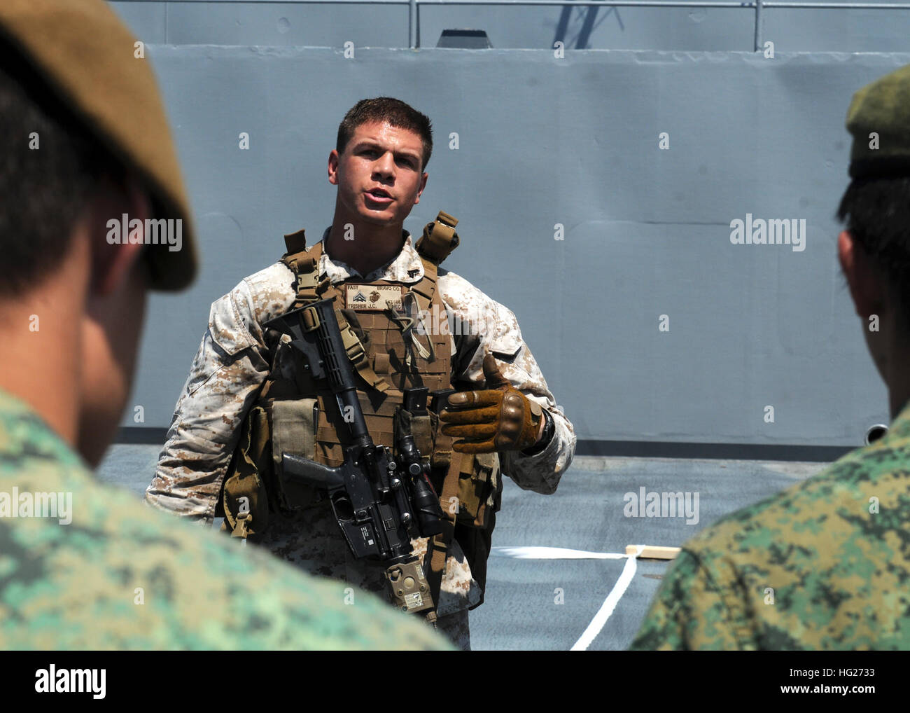 150505-N-KG618-051 SINGAPORE (May 5, 2015) - Cpl. Jay Frisher, center, attached to Fleet Antiterrorism Security Team Pacific, answers questions from members of the Singapore Armed Forces on the main deck of U.S. 7th Fleet flagship USS Blue Ridge (LCC 19). Blue Ridge is conducting a port visit in Singapore to build multilateral partnerships, volunteer through community service projects and explore everything Singapore has to offer, strengthening relationships with the people. (U.S. Navy photo by Mass Communication Specialist 3rd Class Kevin A. Flinn/RELEASED) USS Blue Ridge in Singapore 150505- Stock Photo