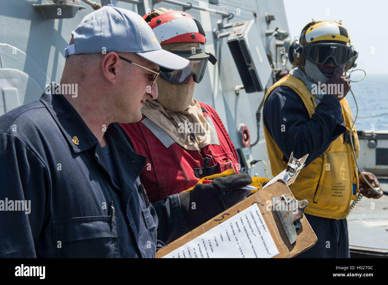 150523-N-VC236-019  GULF OF OMAN (May 23, 2015) - Chief Hull Maintenance Technician Bryan Hatch, from Crestview, Florida, evaluates Damage Controlman 2nd Class Chad McGowan, from Washington, Vermont, during a flight quarters crash and smash drill aboard the guided-missile destroyer USS Farragut (DDG 99). Farragut is deployed to the U.S. 5th Fleet area of operations as part of Theodore Roosevelt Carrier Strike Group supporting Operation Inherent Resolve, strike operations in Iraq and Syria as directed, maritime security operations and theater security cooperation efforts in the region. (U.S. Na Stock Photo