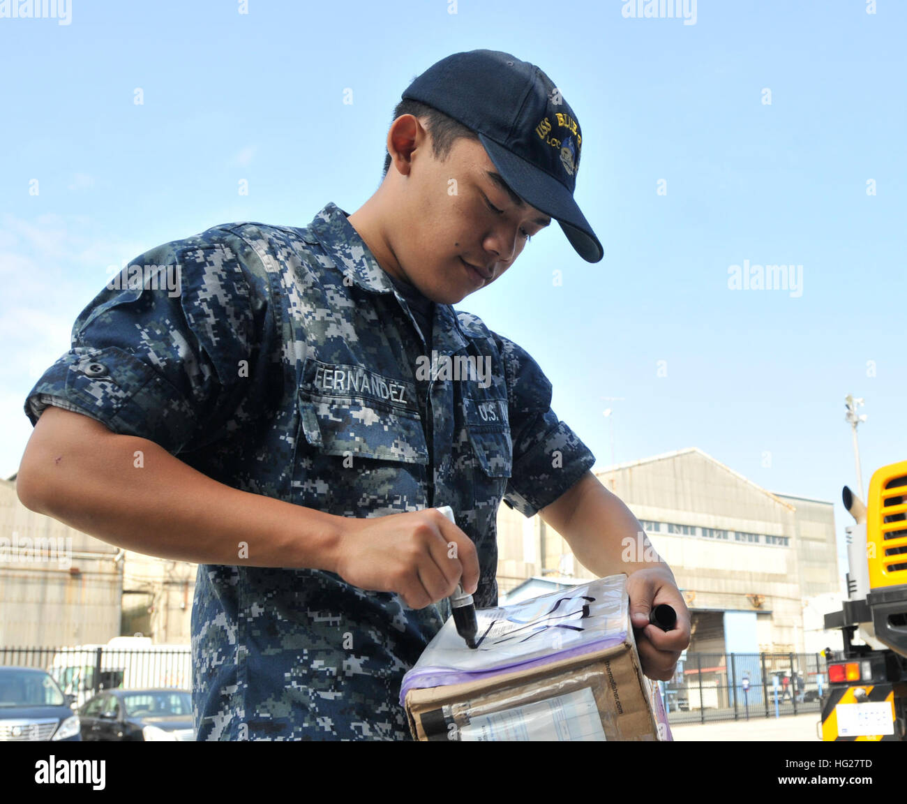 150601-N-LG619-022 YOKOSUKA, Japan (June 1, 2015) - Logistics Specialist Seaman Gemchristian Fernandez, attached to U.S. 7th Fleet flagship USS Blue Ridge (LCC 19), writes processing information on a box  during a supply on load on the pier. Blue Ridge is undergoing a brief maintenance period in preparation for future patrols within the 7th Fleet area of operations. (U.S. Navy photo by Mass Communication Specialist 1st Class Mike Story/Released) USS Blue Ridge operations 150601-N-LG619-022 Stock Photo