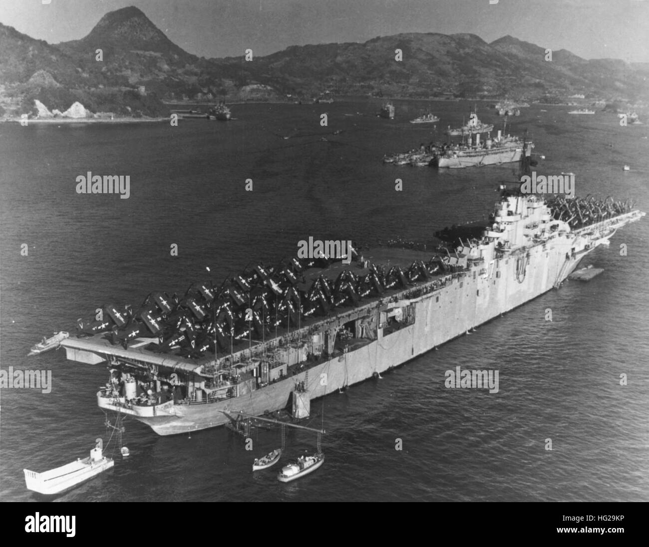 USS Philippine Sea (CV-47) moored at Sasebo, Japan, 3 January 1951, with much of her air group spotted on the flight deck. Planes seen include Douglas AD-4 Skyraiders of Attack Squadron 115 (VA-115), Vought F4U-4B Corsairs of Fighter Squadrons 113 and 114 (VF-113 & VF-114) and Grumman F9F-2 Panthers of Fighter Squadrons 111 and 112 (VF-111 & VF-112). Note: Destroyer tender and destroyers in the middle distance, with USS Juneau (CLAA-119) just beyond; LCM-3 landing craft tied to the carrier's stern; and barge and ship's boats alongside her starboard quarter. Official U.S. Navy Photograph, now i Stock Photo