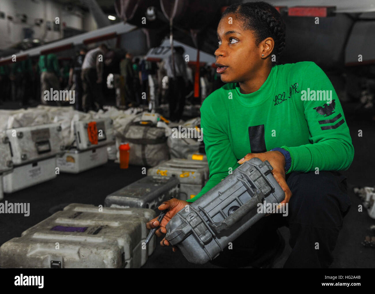 151010-N-CQ428-044  U.S. 5TH FLEET AREA OF OPERATIONS (Oct. 11, 2015) – Logistics Specialist 2nd Class Sheena Lair, from Ocho Rios, Jamaica, organizes an individual materials readiness list for inspection in the hangar bay aboard the aircraft carrier USS Theodore Roosevelt (CVN 71). Theodore Roosevelt is deployed in the U.S. 5th Fleet area of operations supporting Operation Inherent Resolve, strike operations in Iraq and Syria as directed, maritime security operations and theater security cooperation efforts in the region. (U.S. Navy photo by Mass Communication Specialist 3rd Class Jennifer Ca Stock Photo