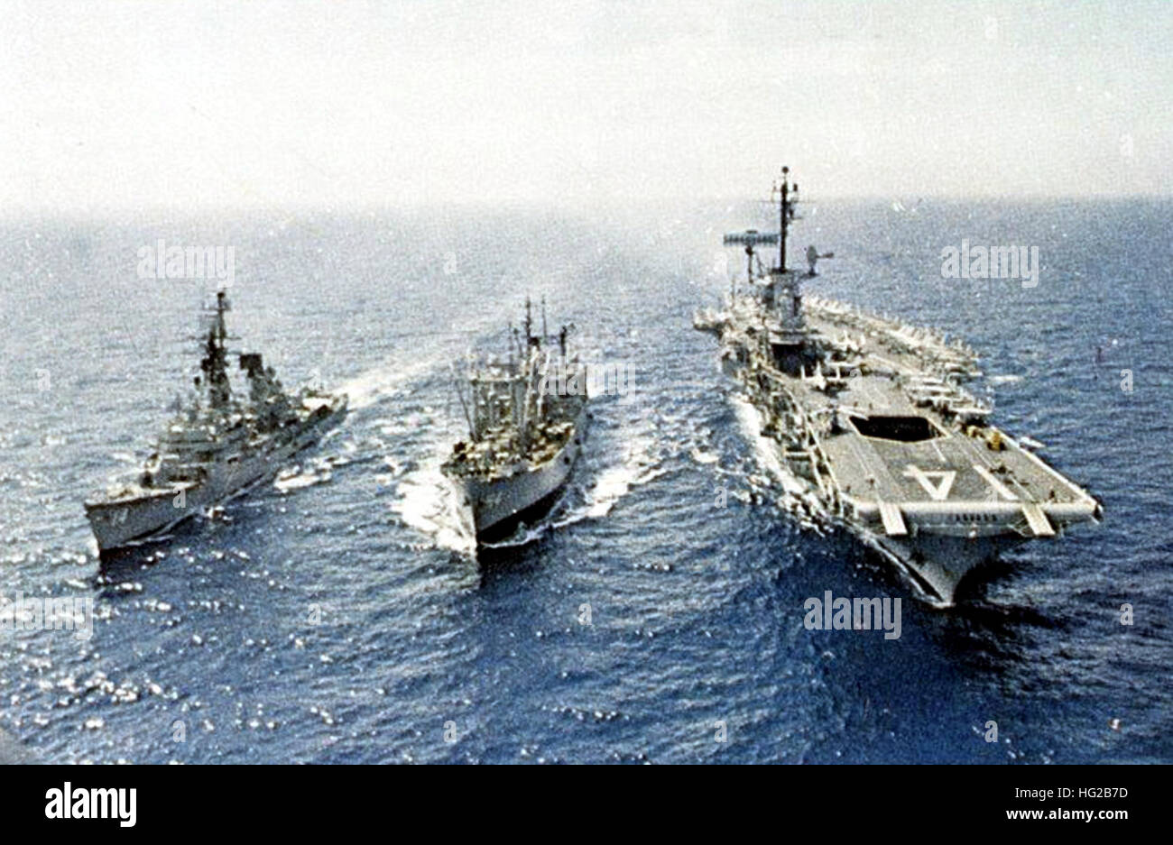 USS Firedrake (AE-14) replenishes USS Ticonderoga (CV-14) and USS Buchanan (DDG-14) in 1969 Stock Photo