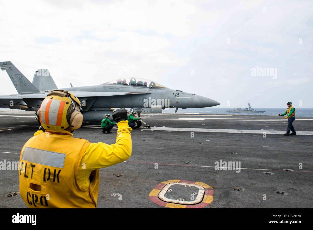 16022-N-DA737-055 PHILIPPINE SEA (Feb. 22, 2016) - Sailors prepare an F/A-18F Super Hornet assigned to the Black Aces of Strike Fighter Squadron (VFA) 41 for launch on USS John C. Stennis' (CVN 74) flight deck while Japanese Maritime Self-Defense Force Murasame-class destroyer JDS Murasame (DD-106) steams alongside. Providing a ready force supporting security and stability in the Indo-Asia-Pacific, Stennis is operating as part of the Great Green Fleet on a regularly scheduled 7th Fleet deployment. (U.S. Navy photo by Mass Communication Specialist 2nd Class Jonathan Jiang / Released) USS John C Stock Photo