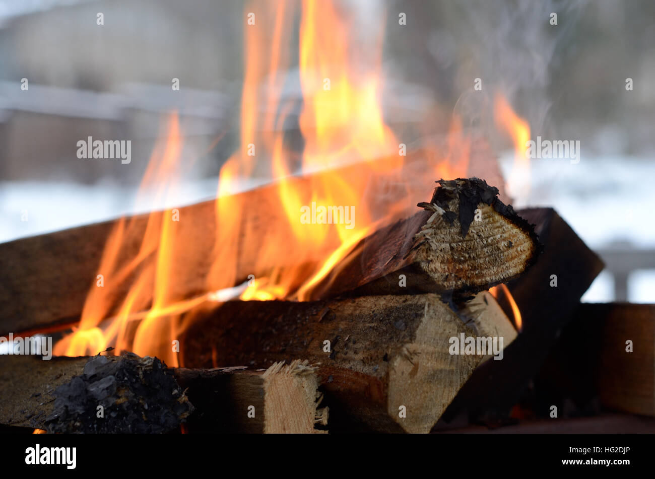 burning firewood in the background of a winter landscape Stock Photo