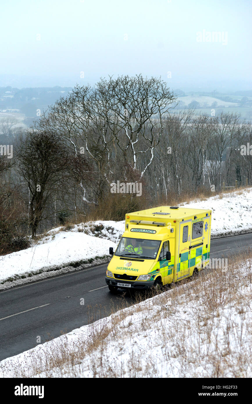 Ambulance on a country road surrounded by snow in winter. Stock Photo