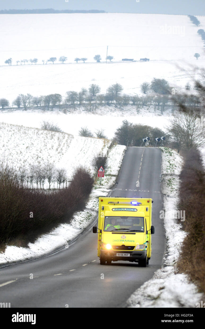 Ambulance on a country road surrounded by snow in winter. Stock Photo