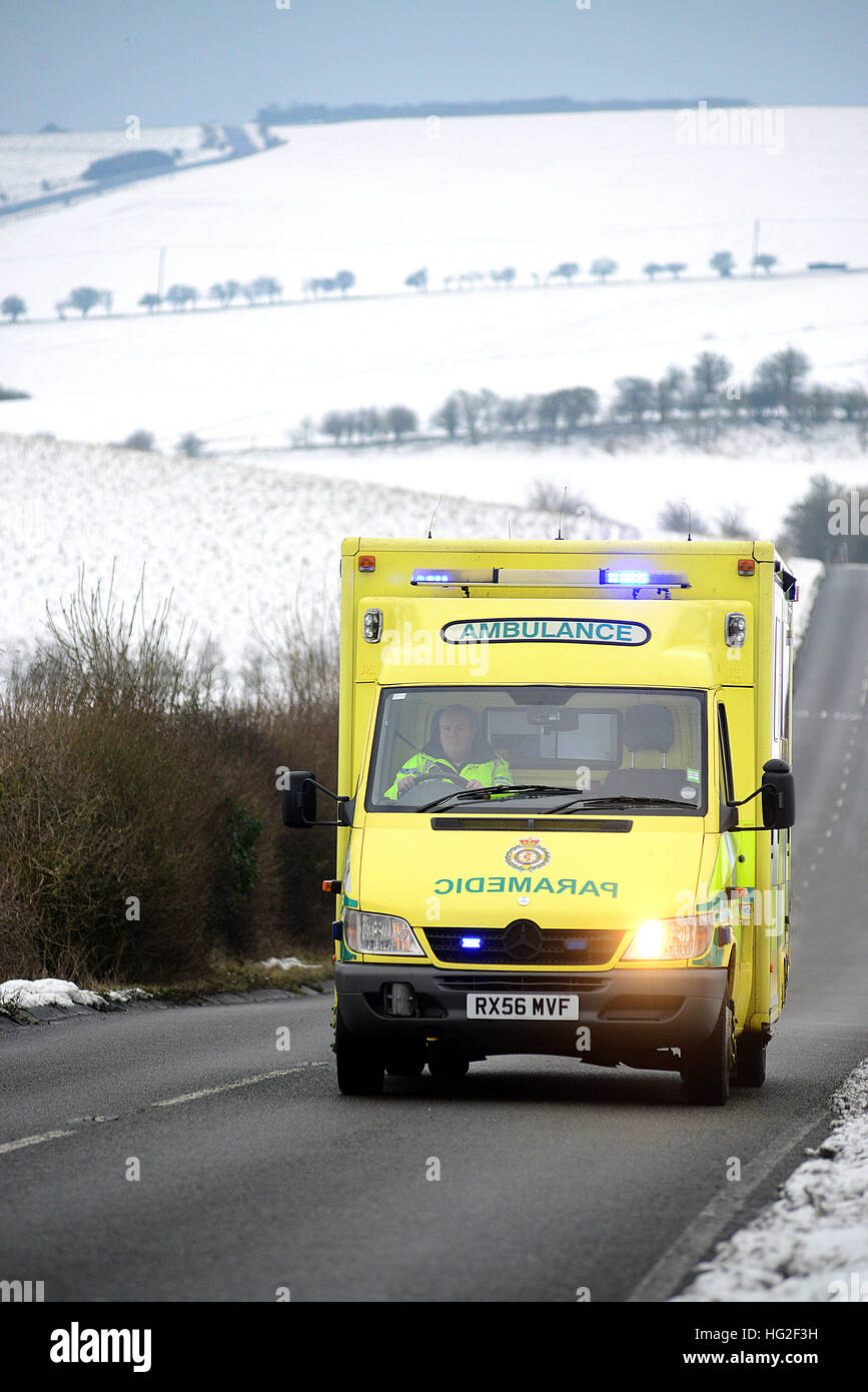 Ambulance on a country road surrounded by snow in winter. Stock Photo