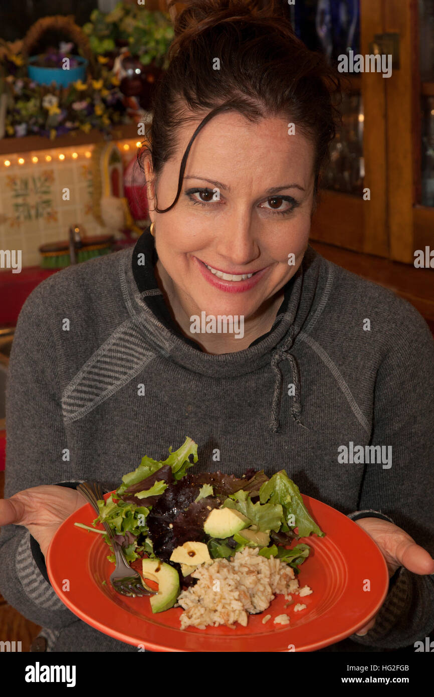 Happy woman showing the healthy dinner that she chose of garden salad and rice. St Paul Minnesota MN USA Stock Photo