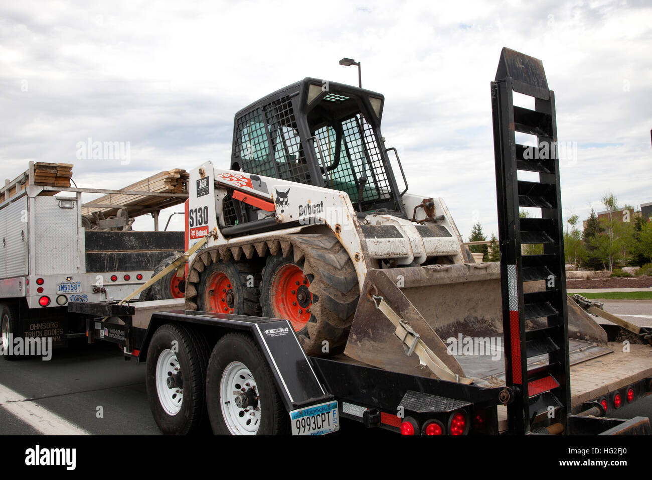 Truck transporting a Bobcat compact track loader on a trailer. St Paul