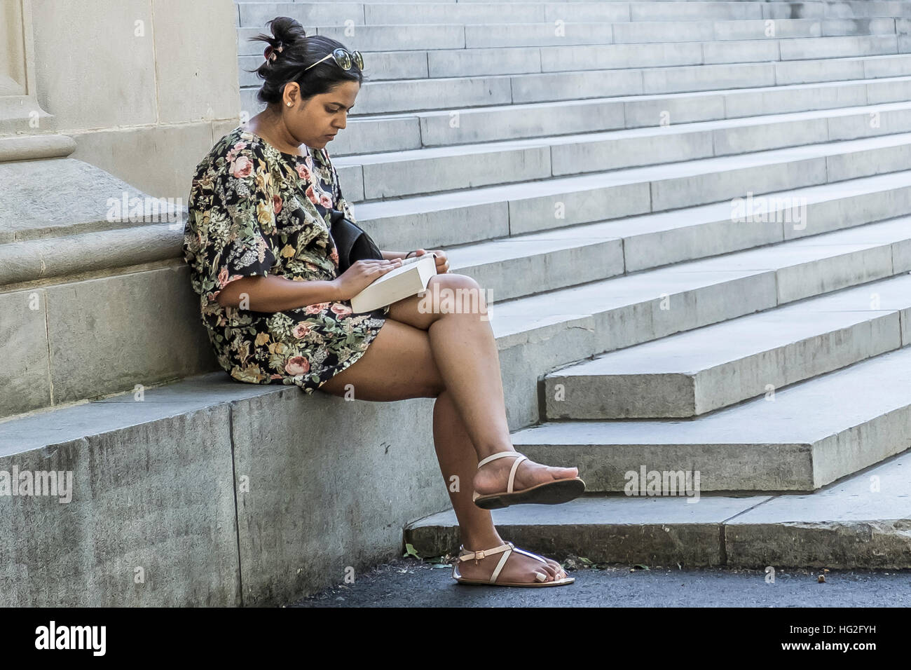Student reading on the library steps in Harvard Yard Harvard Square