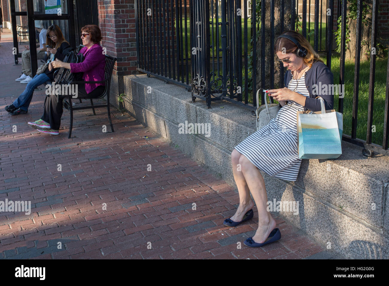 Woman using a laptop in Harvard Square, Cambridge, Massachusetts Stock Photo