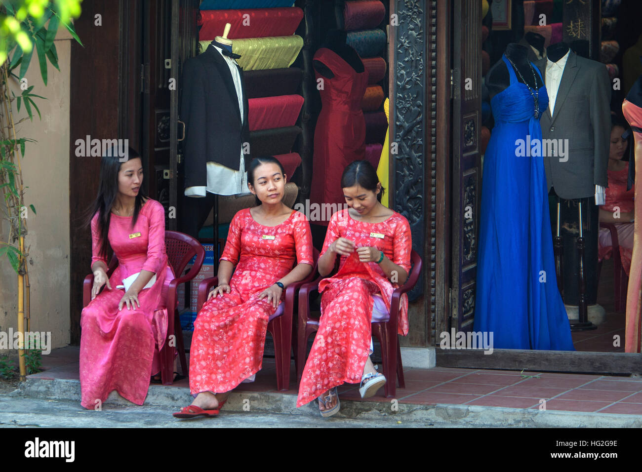 Young women tailor shop assistants wait for customers Hoi An Vietnam Stock Photo