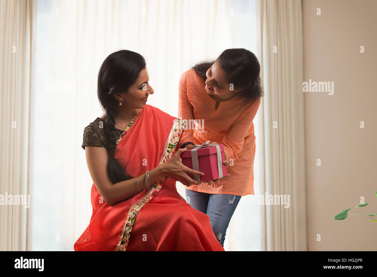 Daughter giving gift to her mother on mother's day Stock Photo