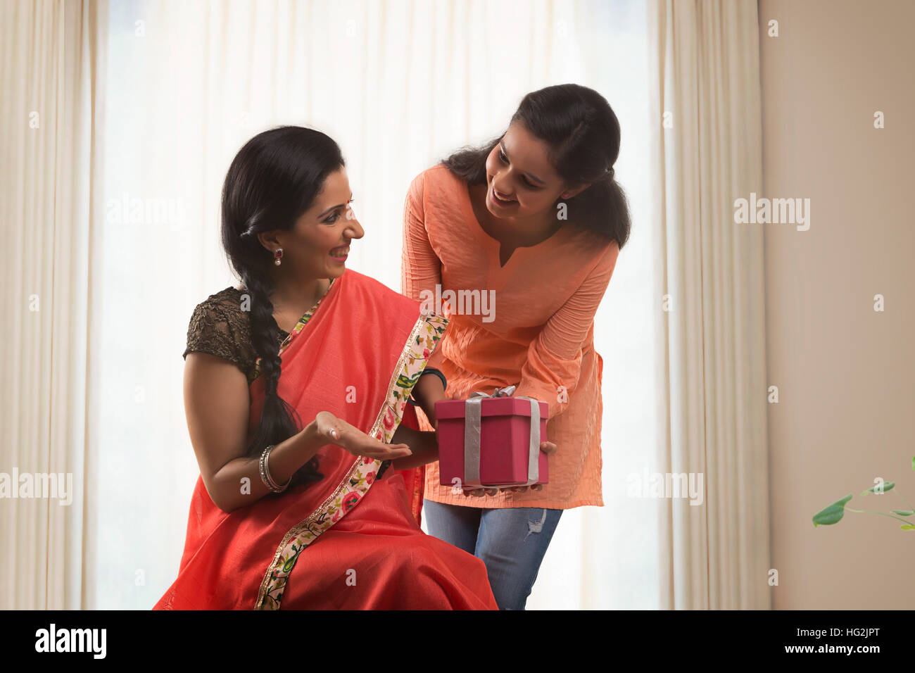 Daughter giving mother birthday gift Stock Photo