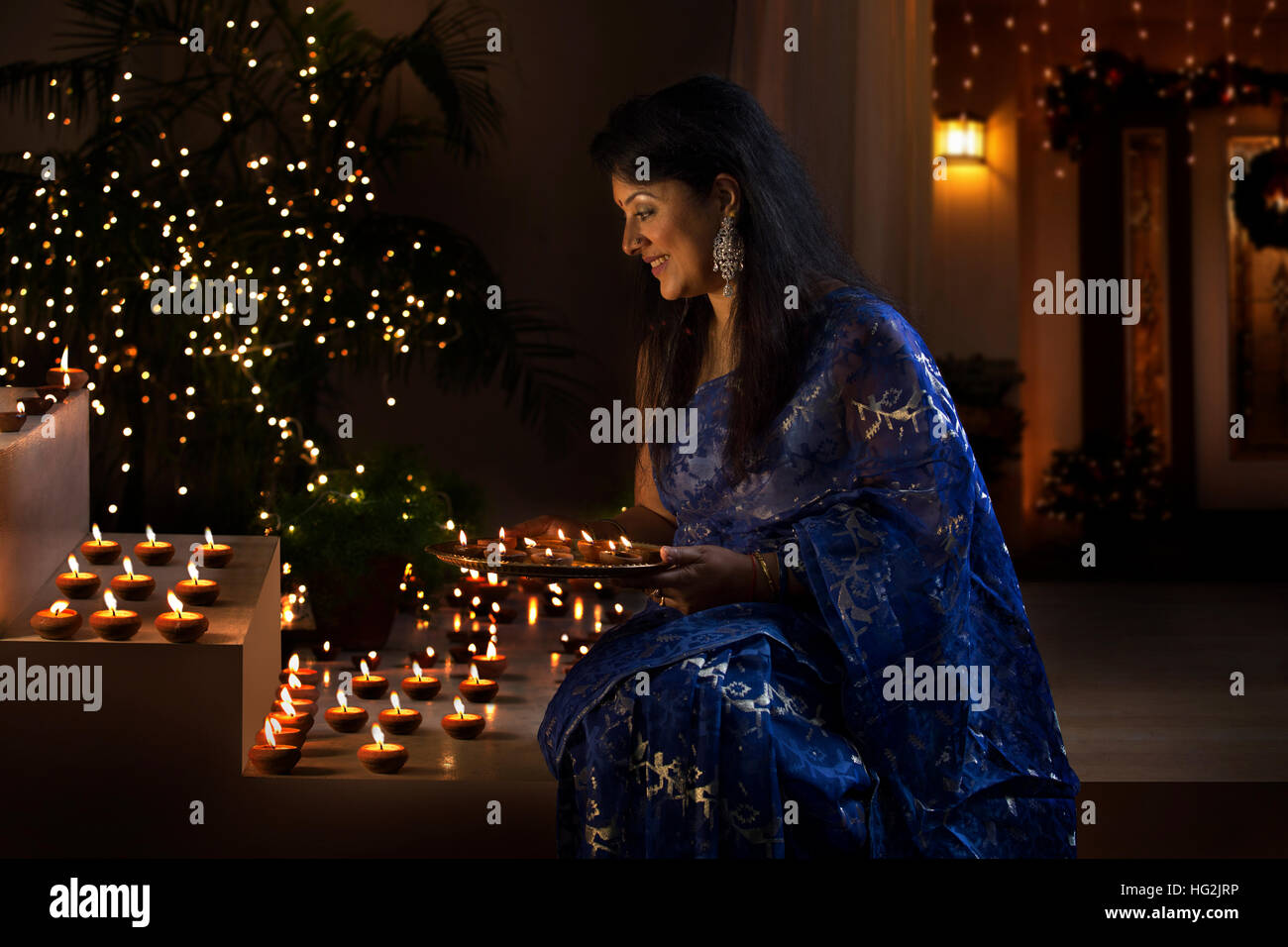 Woman arranging oil lamps at a diwali festival Stock Photo