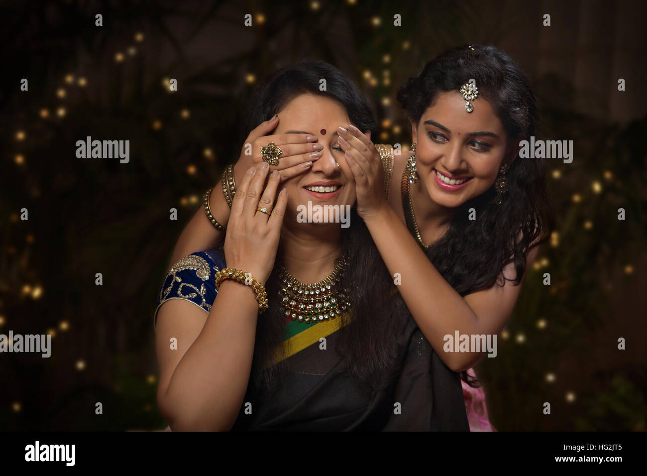Young girl closing her mother's eyes on diwali Stock Photo