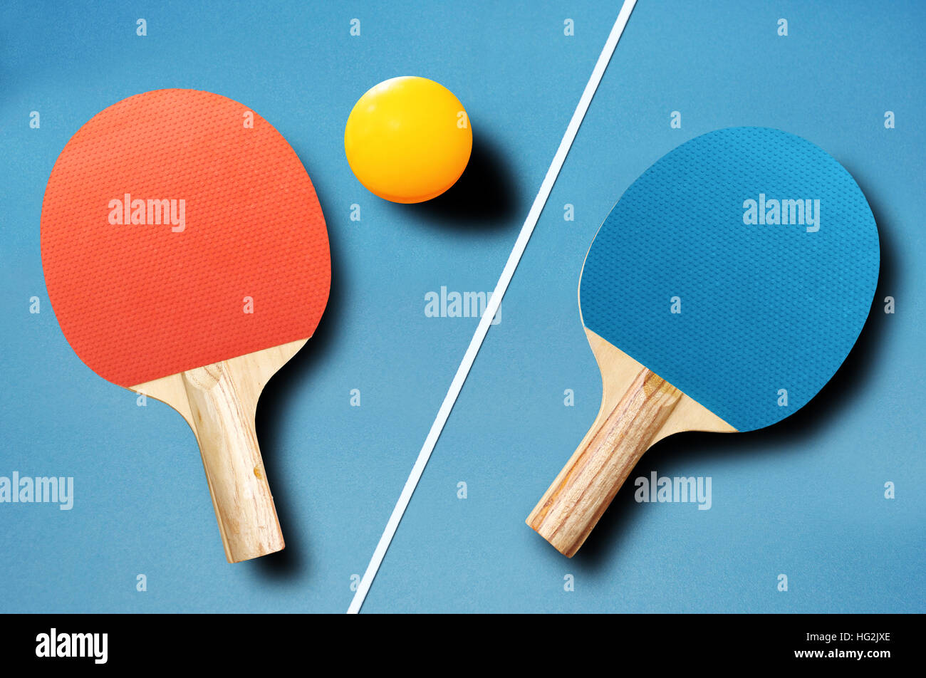 Pin pong ball with red and blue paddle on blue board Stock Photo