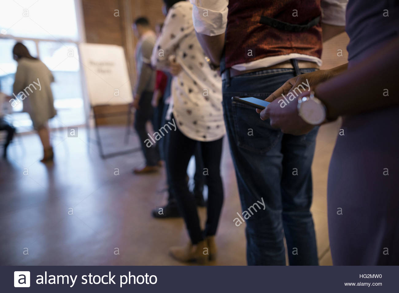 Business people waiting in registration queue texting with cell phone Stock Photo