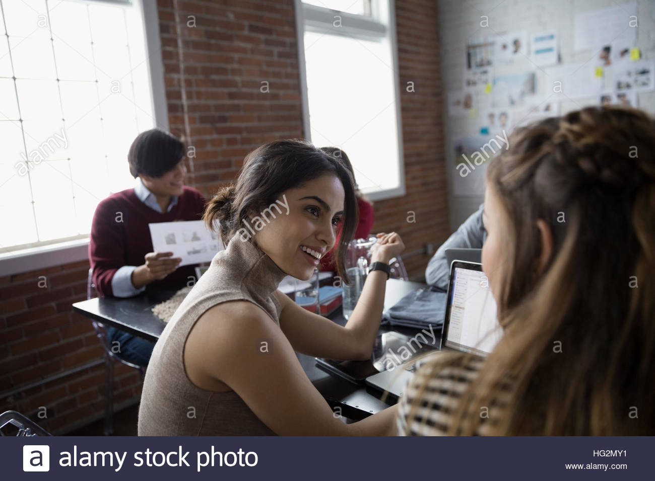 Female hispanic designers talking in conference room meeting Stock Photo