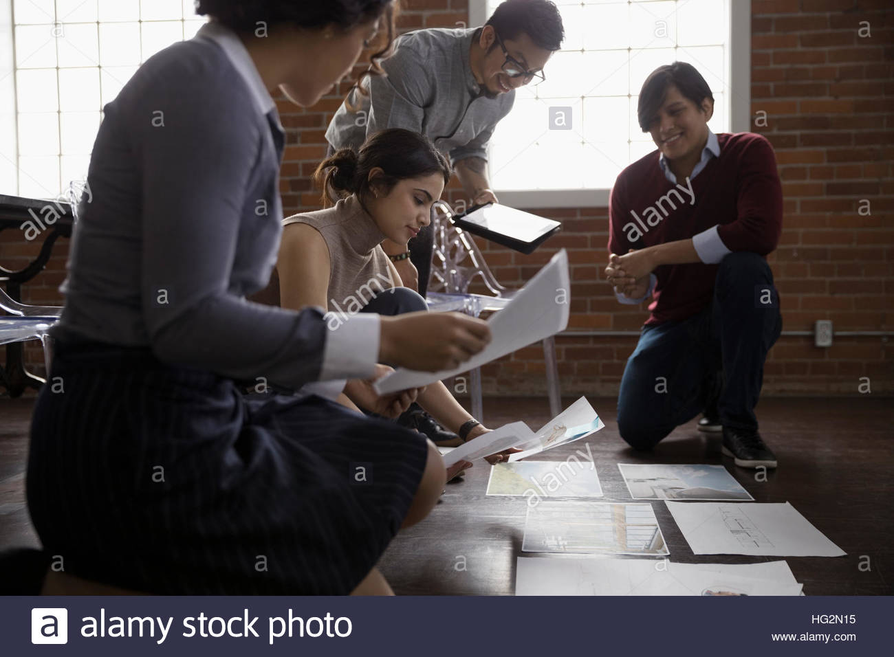 Hispanic designers meeting and brainstorming reviewing proofs in conference room Stock Photo