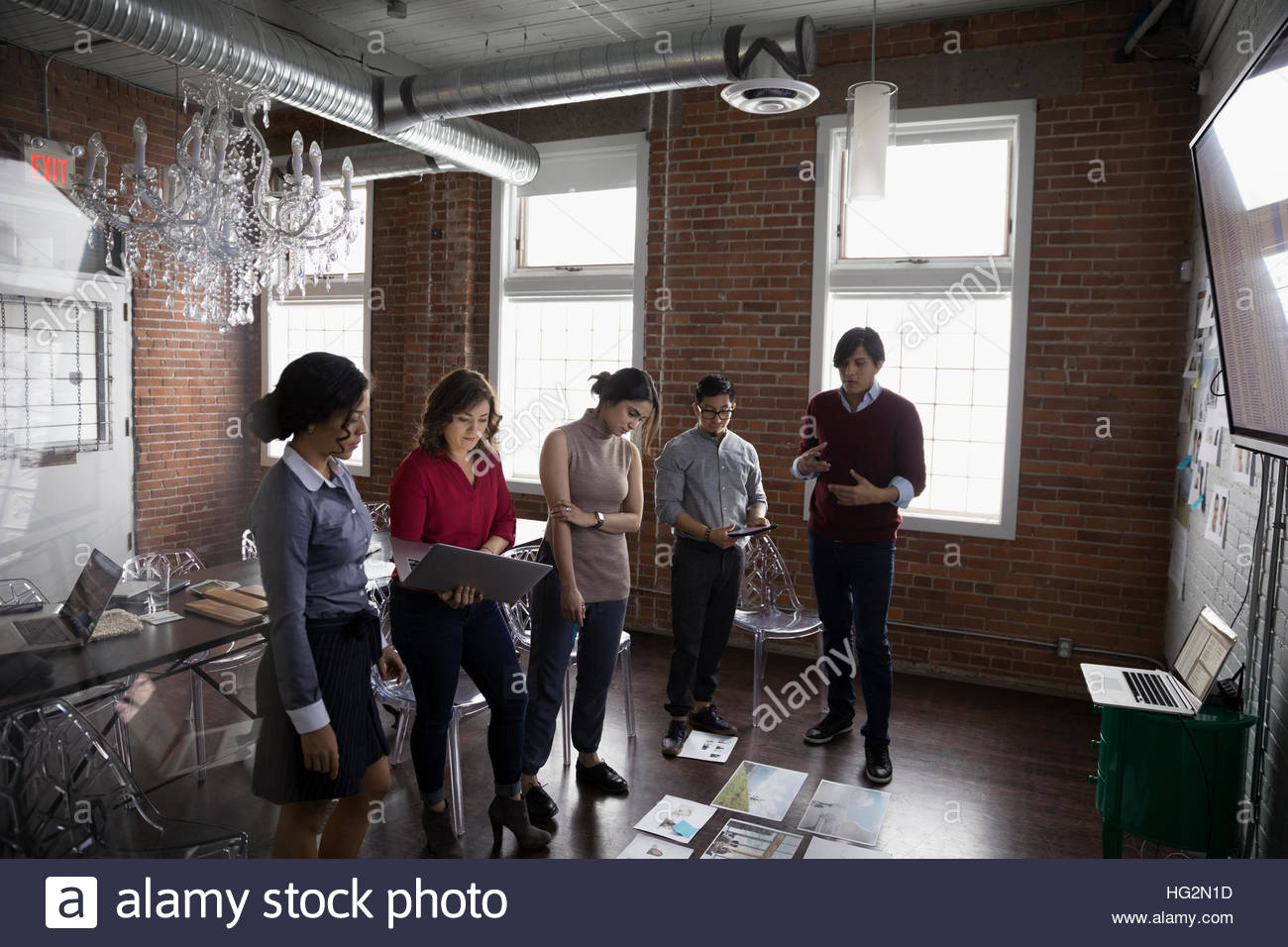 Hispanic designers meeting and brainstorming reviewing proofs in conference room Stock Photo