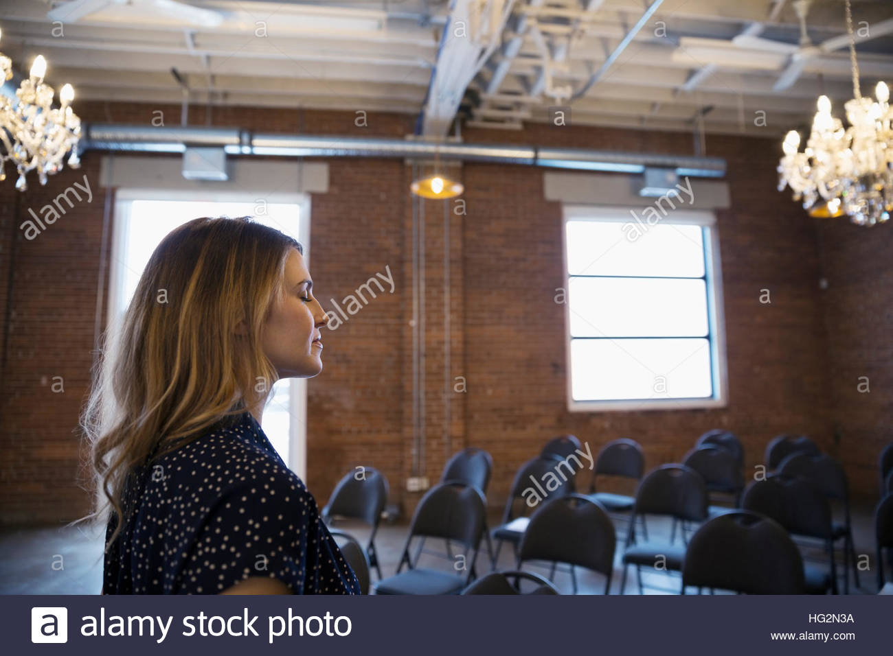 Serene businesswoman with eyes closed in conference room Stock Photo