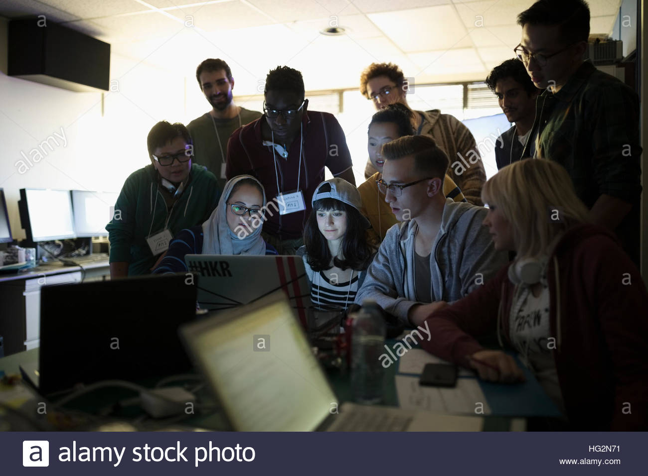 Young hacker team working hackathon at laptop in dark office Stock ...