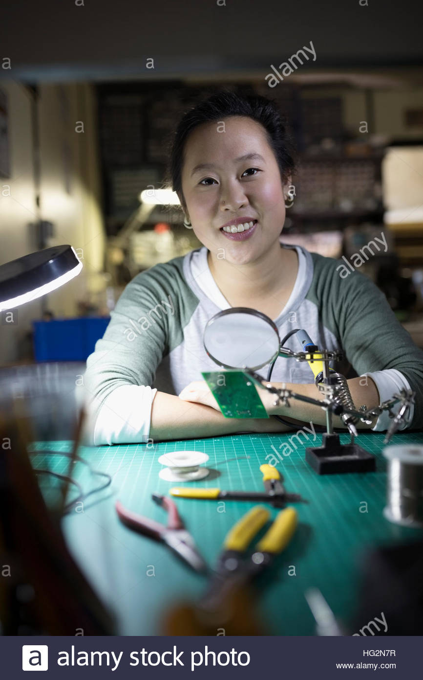 Portrait confident female electronics engineer assembling electronic