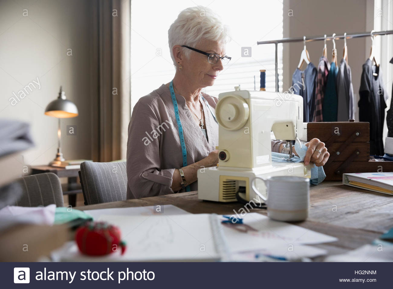 Senior woman seamstress using sewing machine in home office Stock Photo Alamy