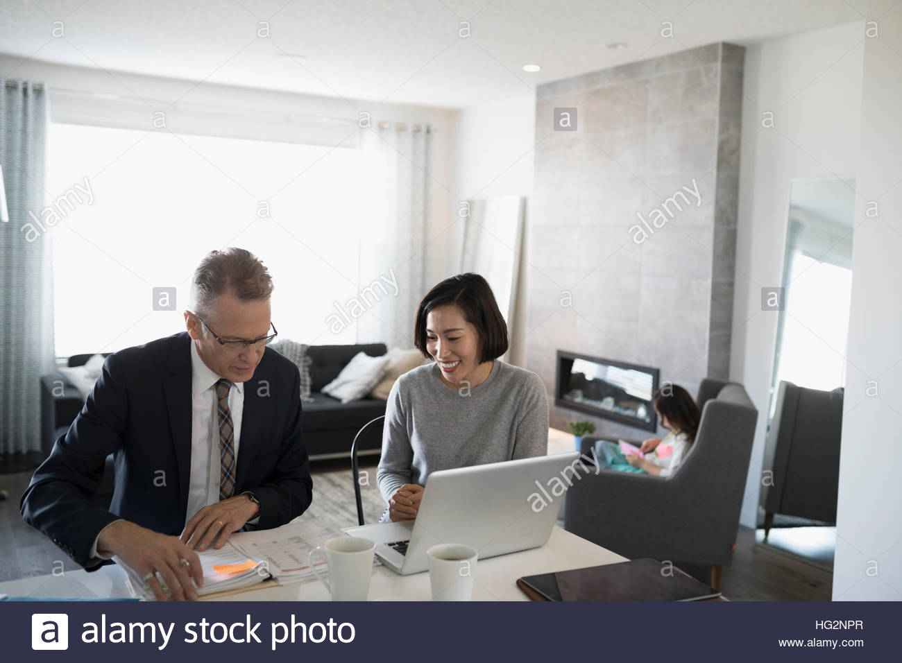Financial advisor and woman with laptop meeting in dining room Stock Photo
