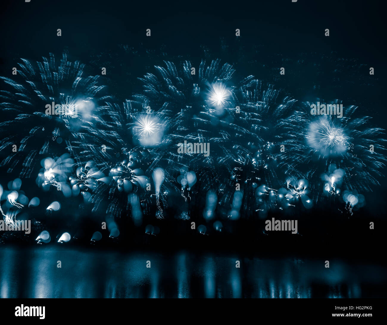 Abstract, blurry, bokeh-style colorful photo of fireworks above the river in New Year Stock Photo