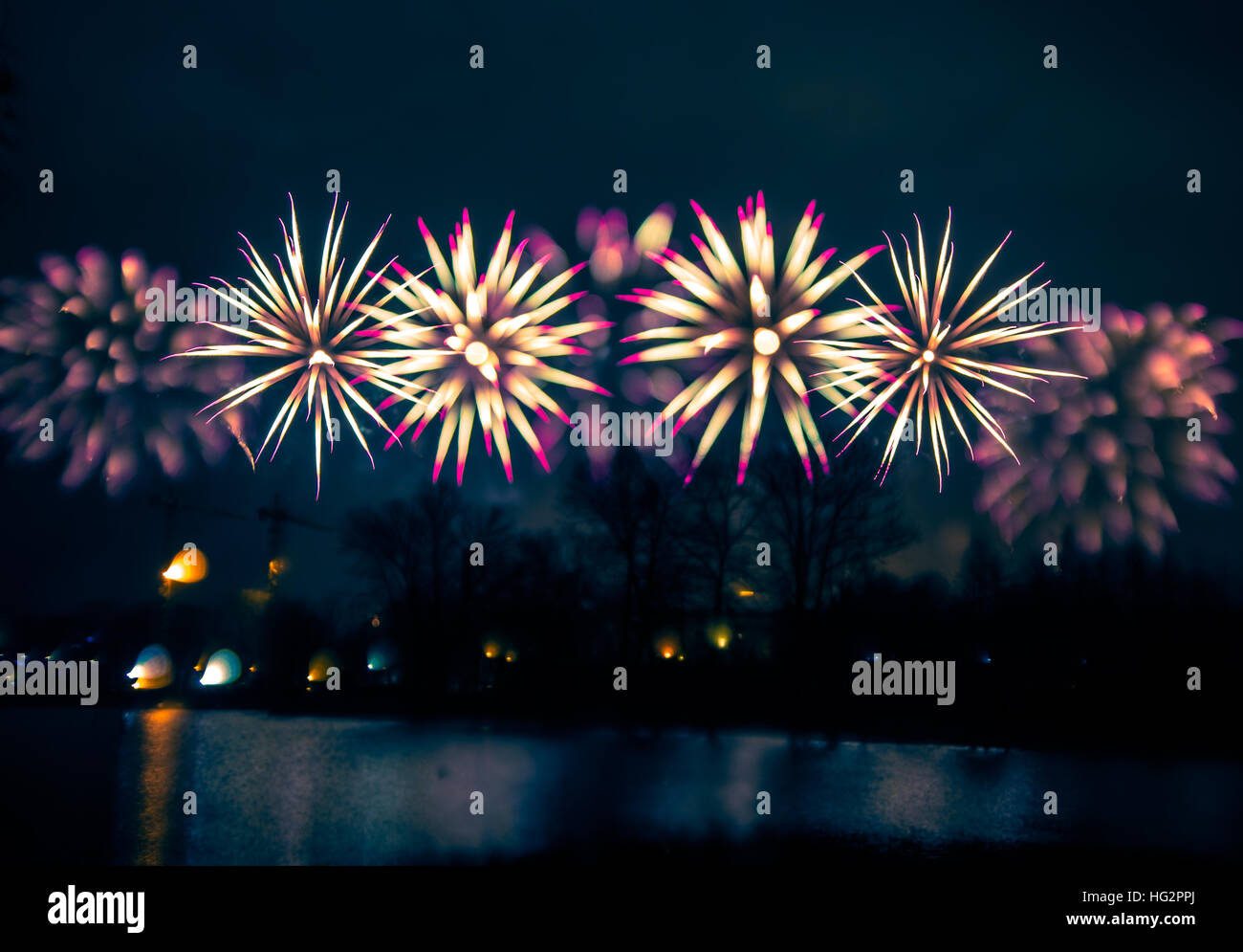 Abstract, blurry, bokeh-style colorful photo of fireworks above the river in New Year Stock Photo