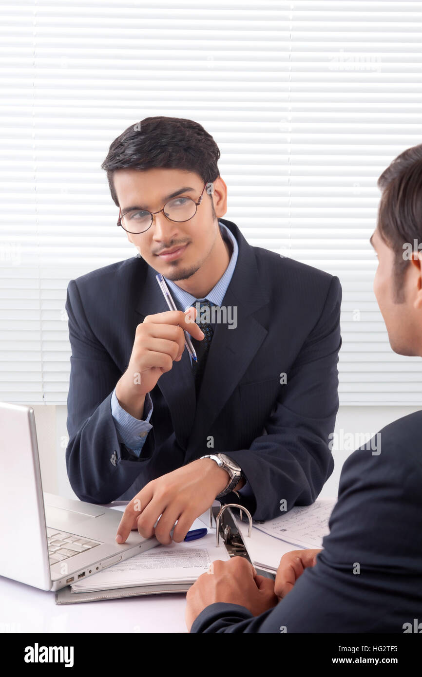 Young professional man listening patiently to another professional man at office Stock Photo