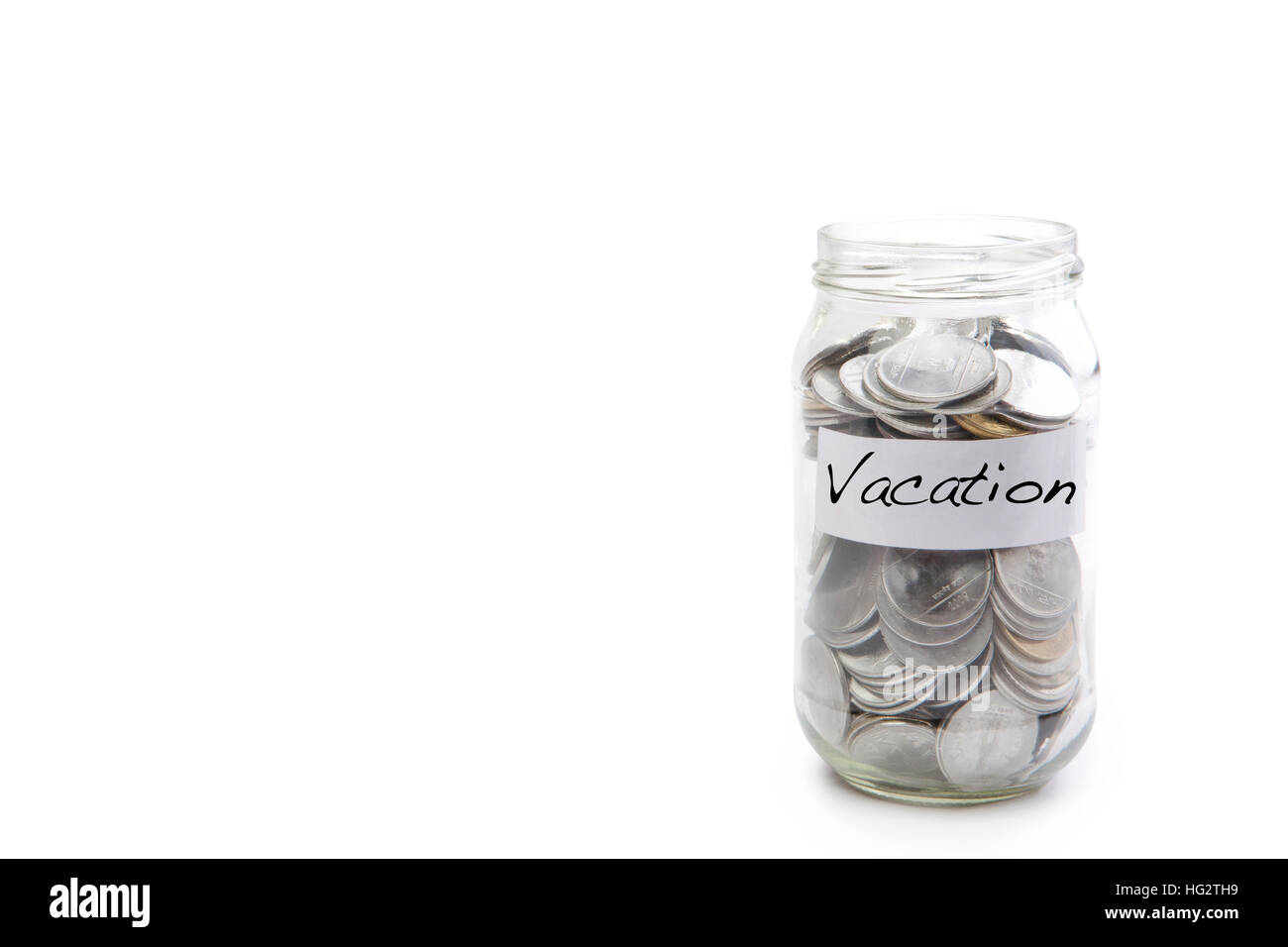 Isolated coins in jar with vacation label - financial concept Stock Photo