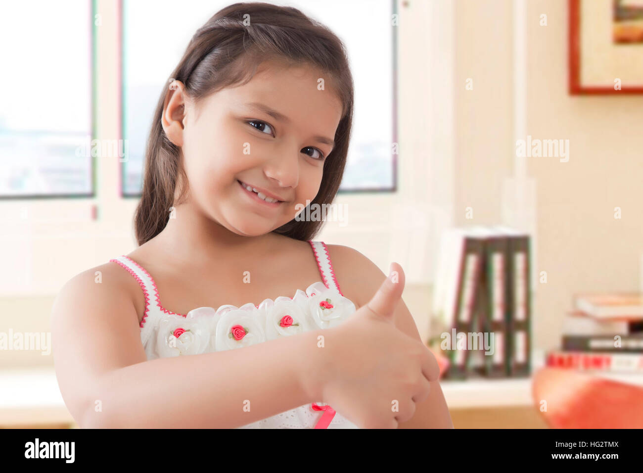 Portrait of smiling girl showing thumbs up Stock Photo - Alamy